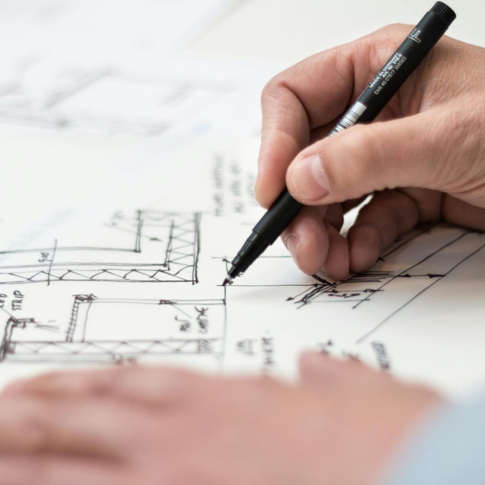 Storage planning blueprint - Close-up of hand drawing intricate technical designs on blueprint with pen